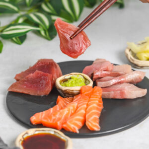 Assorted sashimi slices platter on black tray